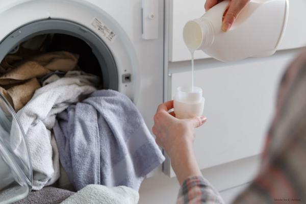 Woman pouring detergent into a washing machine