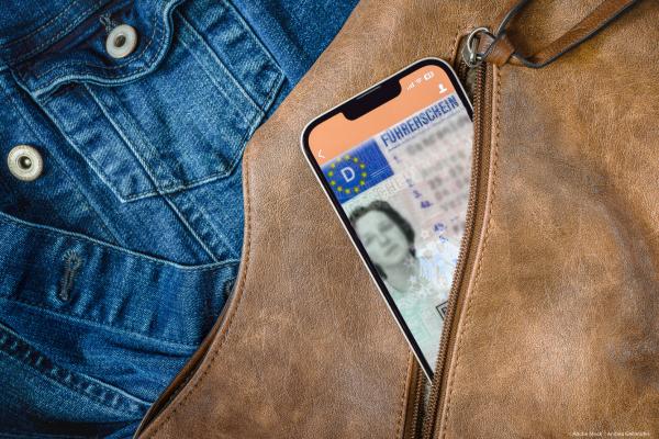 driving licence on smartphone poking out of a jacket pocket
